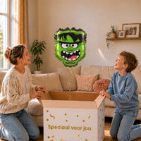Moeder en jongetje openen een cadeaudoos met een groene monsterballon van 45 cm.