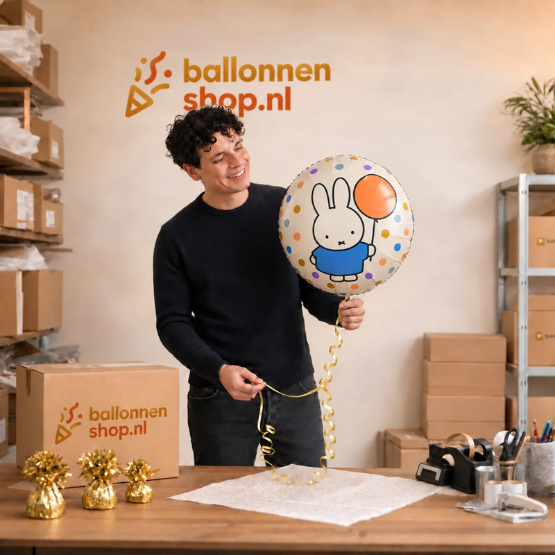Jesse houdt de Nijntje Met Ballon Helium Ballon - Gevuld Met Helium - 46 cm vast in de warme werkplaats van Ballonnenshop.nl.