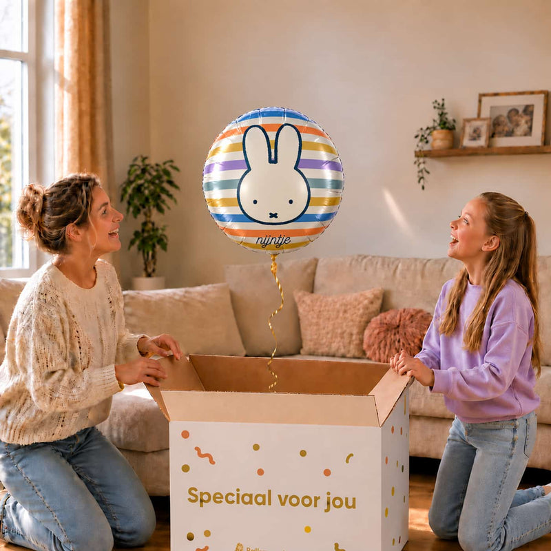 Moeder en meisje bij een gestreepte Nijntje heliumballon van 46 cm boven een open cadeaudoos.