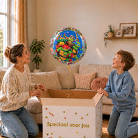 Moeder en jongen pakken de Ninja Turtles ballon van 46 cm uit een feestelijke cadeaudoos.