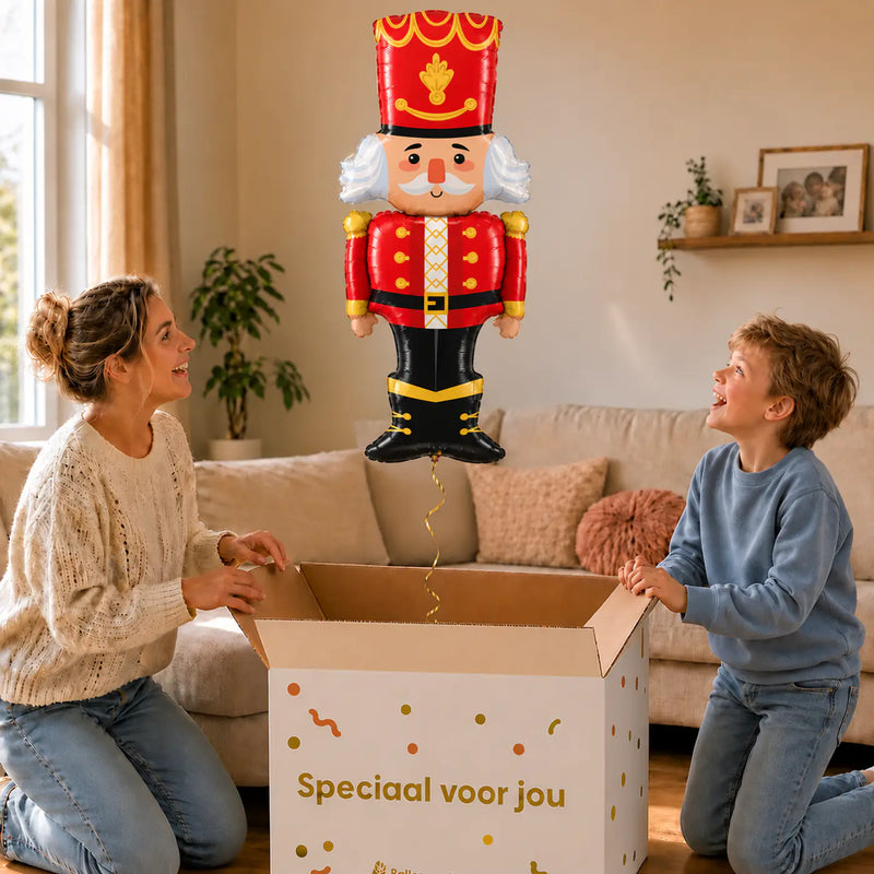Notenkraker Kerst XL Ballon – uitpakmoment met moeder en jongetje in een warme woonkamer – Ballonnenshop.nl