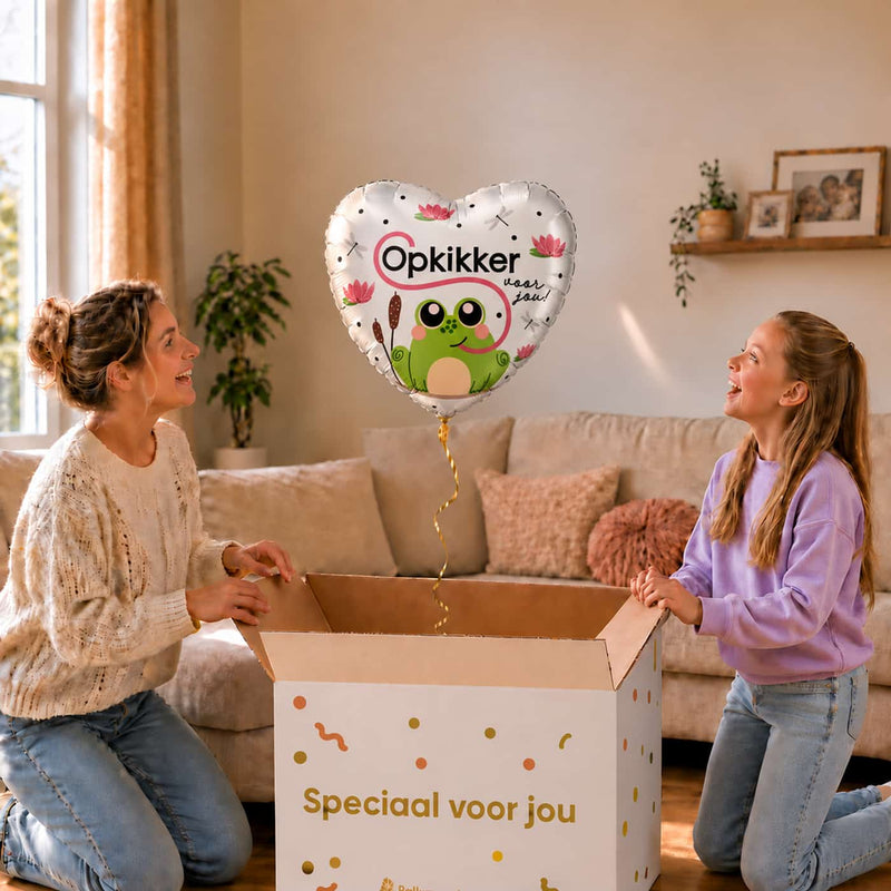 Moeder en meisje kijken naar de hartvormige Opkikker Voor Jou ballon van 43 cm boven de cadeaudoos.