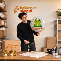 Jesse houdt de Opkikkertje Voor Jou Ballon vast in de warme werkplaats van Ballonnenshop.nl.