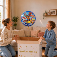 Moeder en kind bekijken de Paw Patrol-heliumballon van 46 cm boven een geopende cadeaudoos.