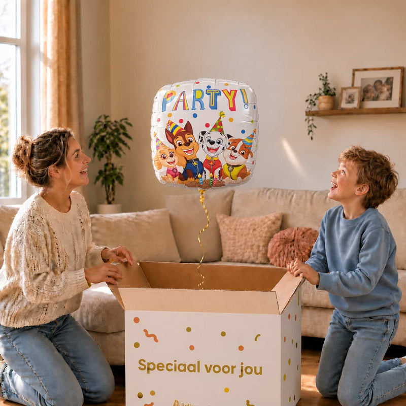 Moeder en jongen bekijken de witte Paw Patrol Party ballon van 46 cm boven de cadeaudoos.