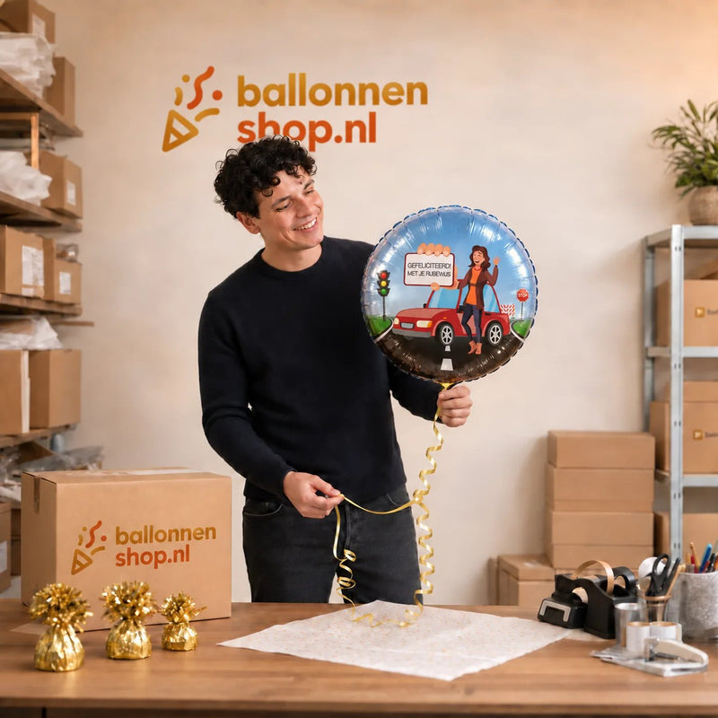 Jesse houdt de Rijbewijs Helium Ballon Vrouw vast in de warme werkplaats van Ballonnenshop.nl.