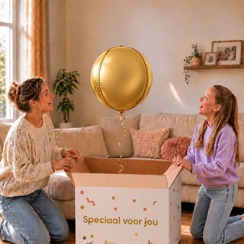 Moeder en meisje pakken een gouden ronde bolballon van 45 cm uit de cadeaudoos.