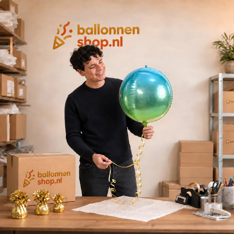 Jesse houdt de Ronde Helium Ballon Blauw & Groen vast in de warme werkplaats van Ballonnenshop.nl.