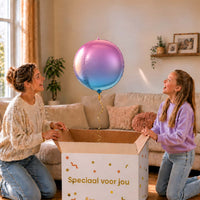 Moeder en meisje bekijken de paars-blauwe ronde bolballon van 45 cm boven de cadeaudoos.