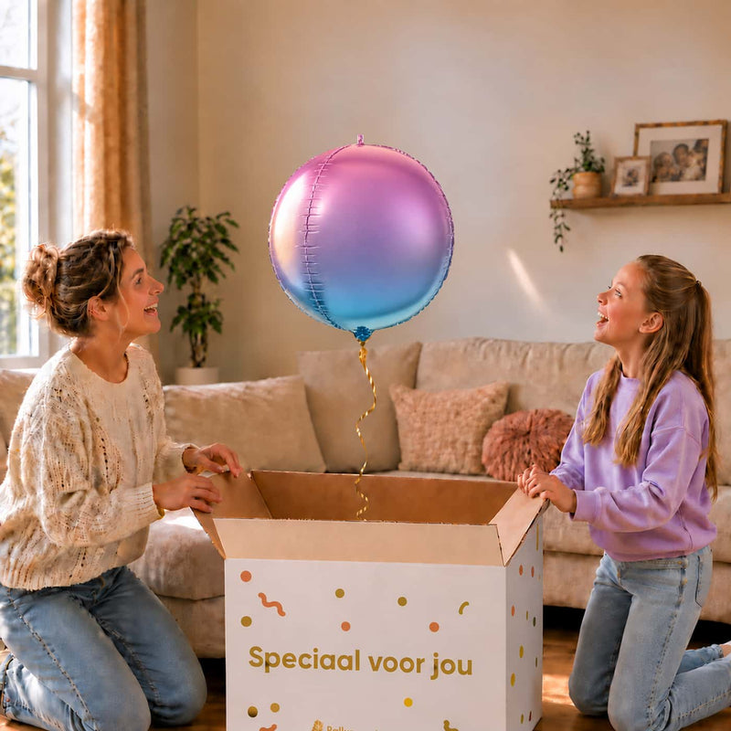 Moeder en meisje bekijken de paars-blauwe ronde bolballon van 45 cm boven de cadeaudoos.