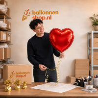 Jesse houdt de Rood Hart helium ballon vast in de warme werkplaats van Ballonnenshop.nl.