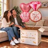 Een feestelijk huwelijksmoment met She Said Yes XL Trosje Ballonnen boven een open Speciaal voor jou-doos in een warme woonkamer.