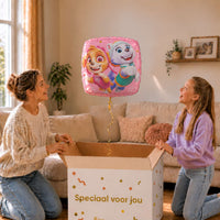 Moeder en meisje bekijken de roze vierkante Skye en Everest Paw Patrol ballon van 46 cm boven de cadeaudoos.