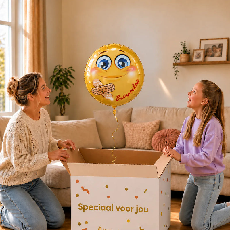 Moeder en meisje pakken een gele Smiley Beterschap heliumballon van 45 cm met pleisters uit.