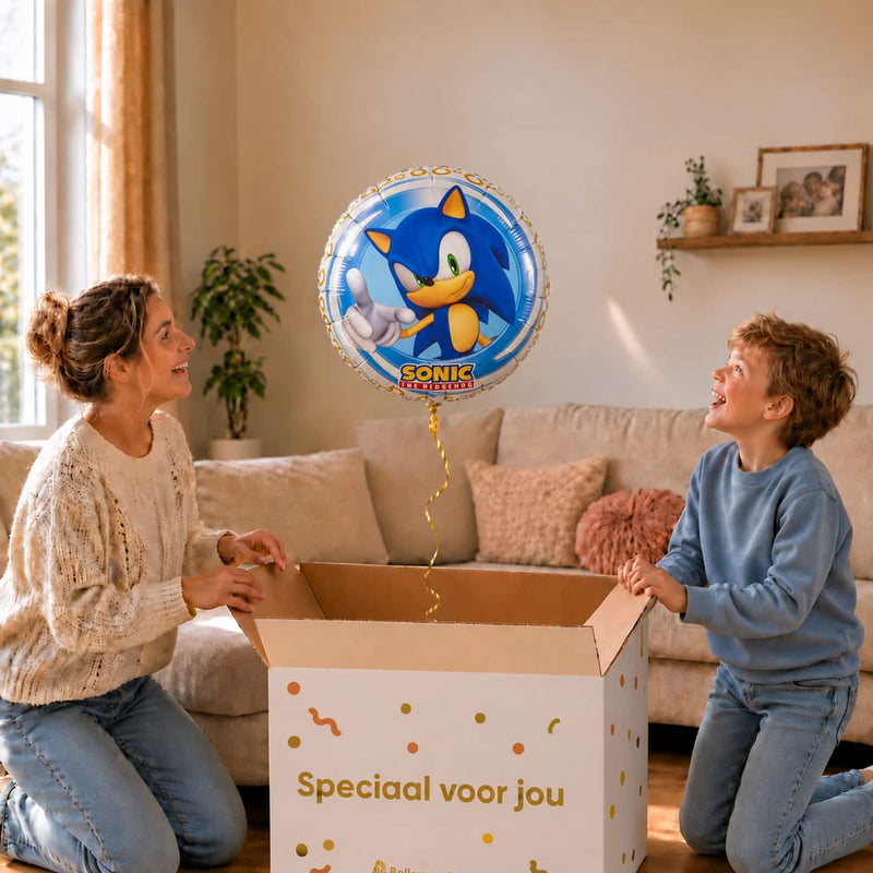 Jongen en moeder bekijken een Sonic heliumballon van 46 cm boven de geopende cadeaudoos.