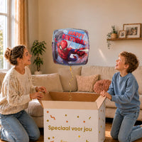 Moeder en jongen bekijken een Spiderman Happy Birthday-ballon boven de geopende cadeaudoos ‘Speciaal voor jou’ in zacht warm licht.