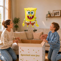 Moeder en jongen bekijken een SpongeBob-ballon van 71 cm met gouden lint boven de geopende cadeaudoos ‘Speciaal voor jou’.