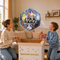 Moeder en jongen bekijken een Star Wars-ballon van 68 cm met gouden lint boven de geopende cadeaudoos ‘Speciaal voor jou’.