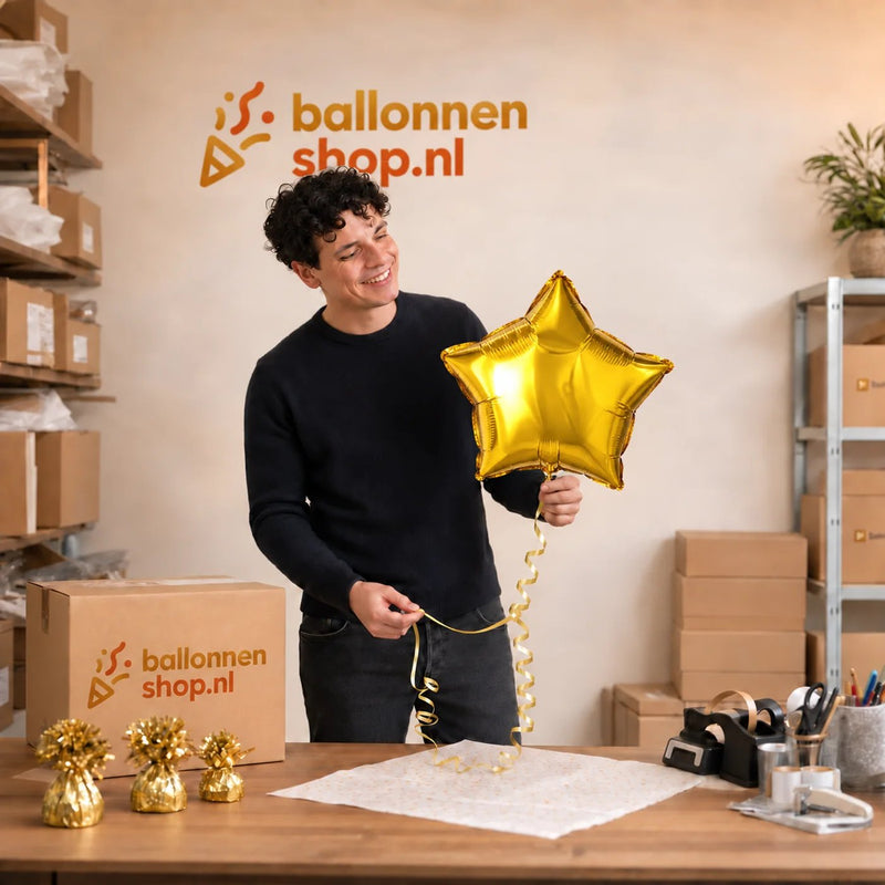 Jesse houdt de Ster Goud Helium Ballon vast in de warme werkplaats van Ballonnenshop.nl.