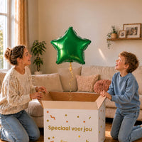 Jongen en moeder bekijken een groene stervormige heliumballon van 46 cm boven de open cadeaudoos.