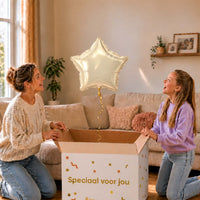 Moeder en meisje pakken een ivoorkleurige sterballon van 46 cm uit de cadeauverpakking.