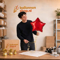 Jesse houdt de Ster Rood Helium Ballon vast in de warme werkplaats van Ballonnenshop.nl.