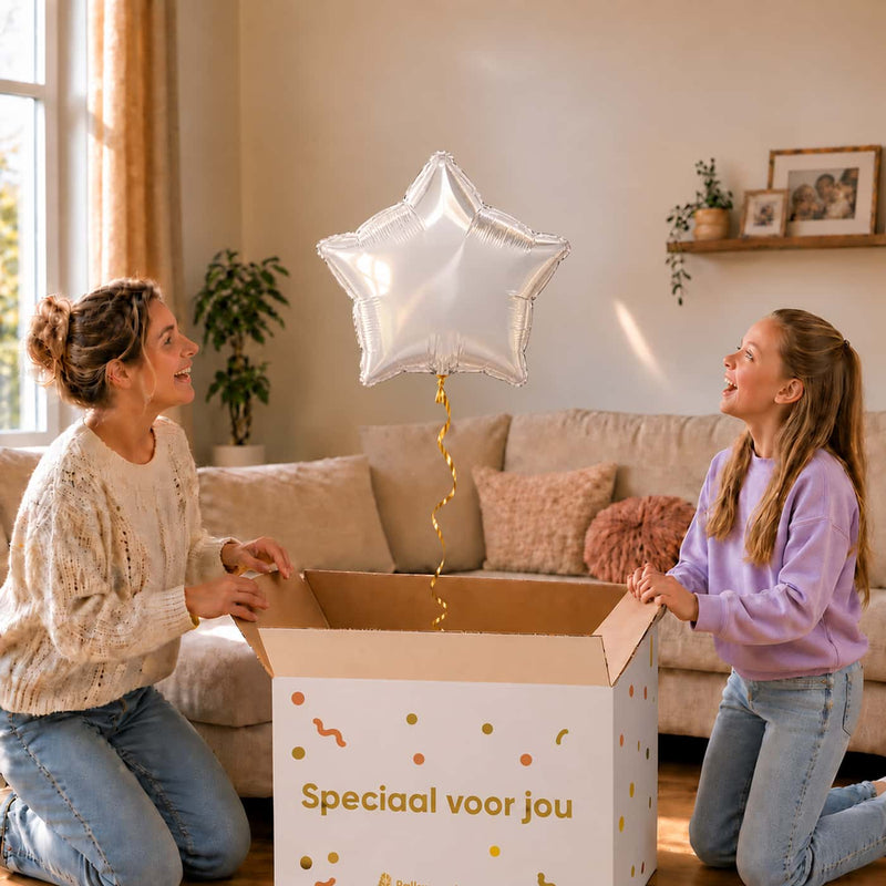Meisje en moeder bekijken een witte stervormige heliumballon van 46 cm boven de cadeauverpakking.