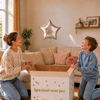 Moeder en jongen pakken een zilveren stervormige heliumballon van 46 cm uit.