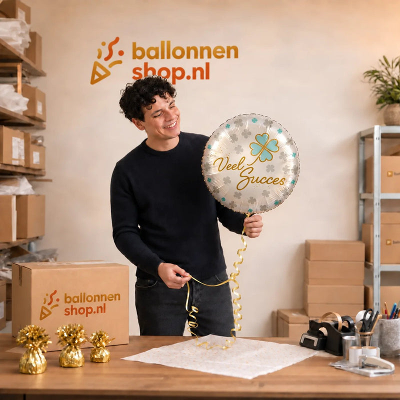 Jesse houdt de Veel Succes Helium Ballon vast in de warme werkplaats van Ballonnenshop.nl.