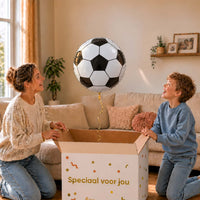Moeder en jongen openen een cadeaudoos met een zwart-witte voetbal heliumballon van 45 cm.