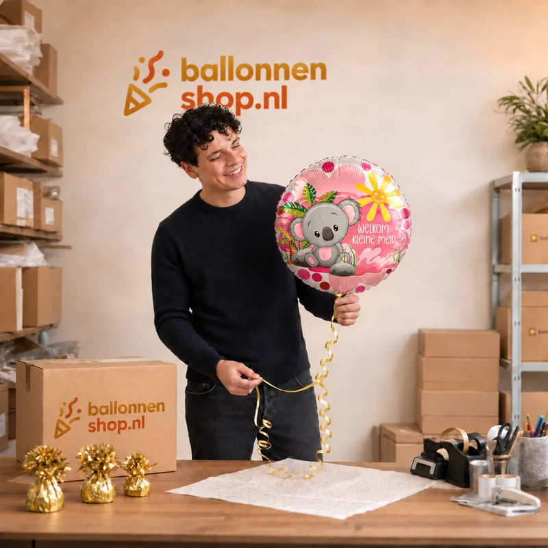 Jesse houdt de Welkom Kleine Meid Helium Ballon vast in de warme werkplaats van Ballonnenshop.nl.