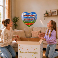 Moeder en meisje openen een cadeaudoos met een hartvormige Welkom Thuis heliumballon van 46 cm.