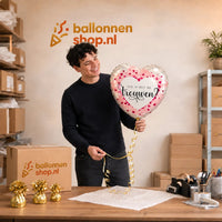 Jesse houdt de Wil Je Trouwen Helium Ballon vast in de warme werkplaats van Ballonnenshop.nl.
