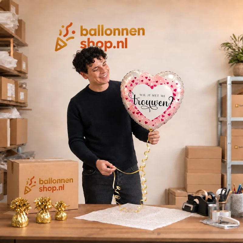 Jesse houdt de Wil Je Trouwen Helium Ballon vast in de warme werkplaats van Ballonnenshop.nl.