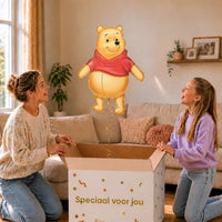 Moeder en meisje bekijken een Winnie de Poeh-ballon van 73 cm met gouden lint boven de geopende cadeaudoos ‘Speciaal voor jou’.