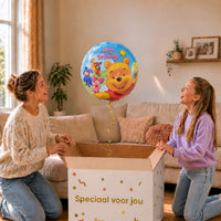 Moeder en meisje openen een cadeaudoos met een Winnie the Pooh Happy Birthday heliumballon van 45 cm.