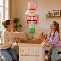 Notenkraker Kerst Pastel XL – uitpakmoment met moeder en meisje in een warme woonkamer – Ballonnenshop.nl