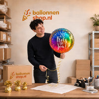 Jesse houdt de Zo Trots Op Jou Ballon vast in de warme werkplaats van Ballonnenshop.nl.